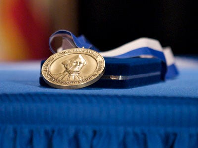 The Cura Personalis medal rests on a blue tableclothed table