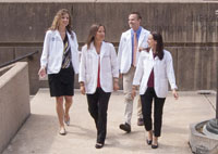Four medical students walk together outdoors in a group