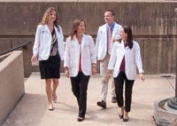 Four medical students walk together outdoors in a group