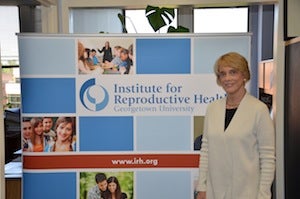 Victoria Jennings stands in front of a sign for the Institute for Reproductive Health