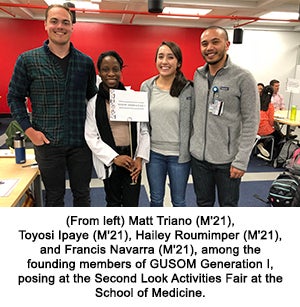 (From left) Matt Triano (M'21), Toyosi Ipaye (M'21), Hailey Roumimper (M'21), and Francis Navarra (M'21), among the founding members of GUSOM Generation I, posing at the Second Look Activities Fair at the School of Medicine. 