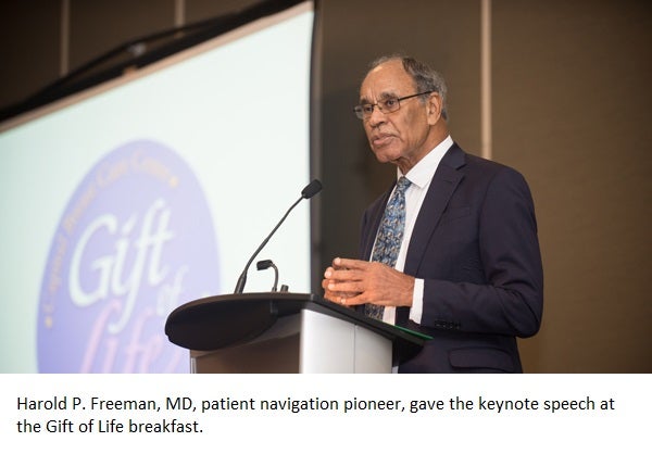 Dr. Harold Freeman stands at a podium and speaks. Behind him the words "Gift of Life" appear on a screen.