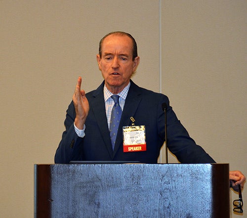 Stephen R.T. Evans stands at a podium