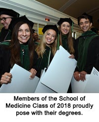 Members of the School of Medicine Class of 2018 proudly pose with their degrees.