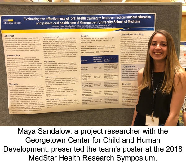 Maya Sandalow stands before a board displaying her team's poster at the 2018 MedStar Health Research Symposium