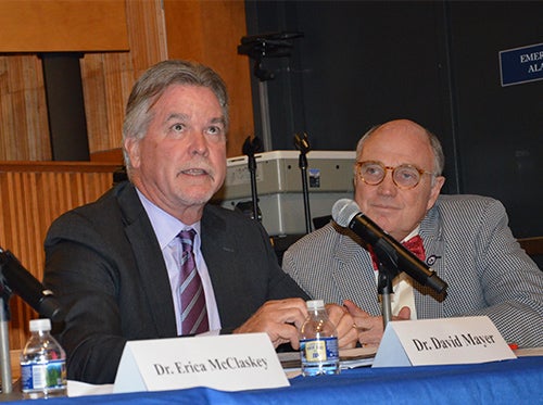 David Mayer glances upward while speaking. Seated next to him at the table is Dean Stephen Mitchell.