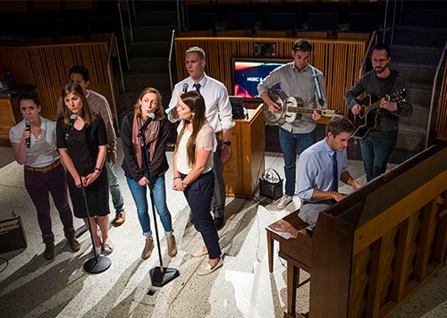 A group of medical students sings and plays musical instruments before an audience