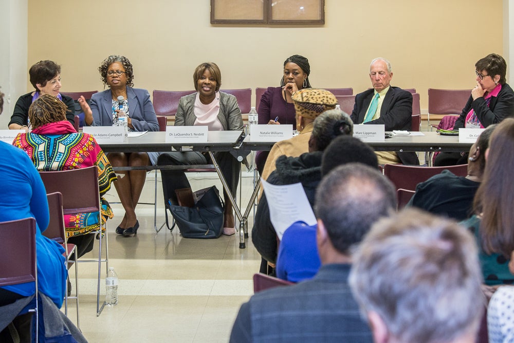 A group of panelists sits at a table before a group of community members from Washington, D.C.'s Wards 7 & 8