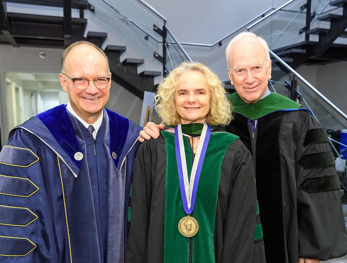 Jack DeGioia, Nora Volkow, and Dr. Ed Healton stand side by side in academic regalia