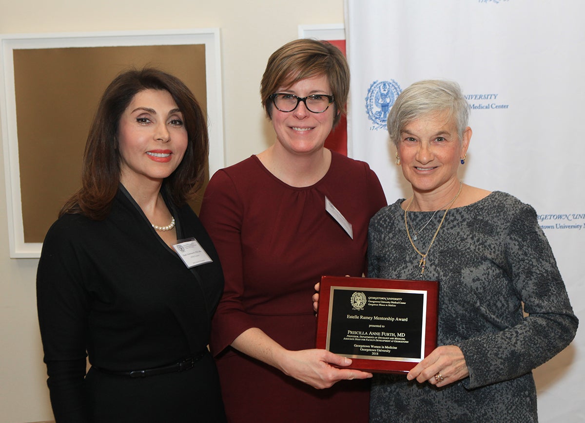 Three women from Georgetown Women in Medicine stand side by side