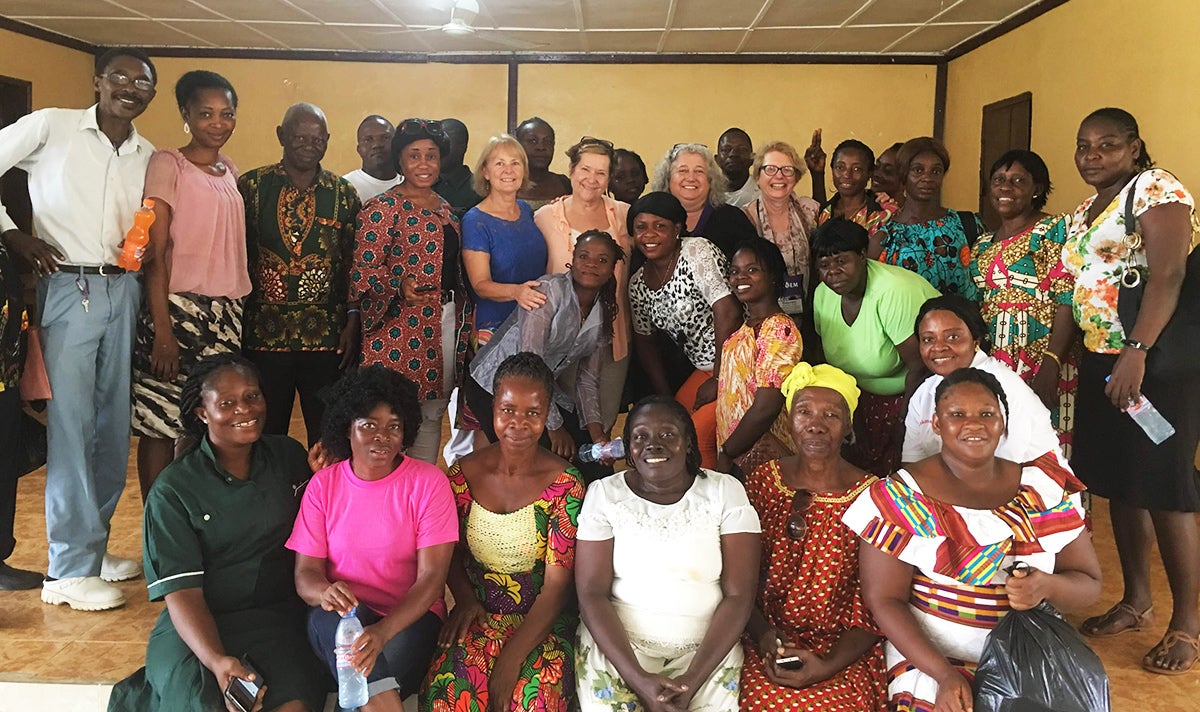 A large group of workshop participants stands together for a group photo in Liberia