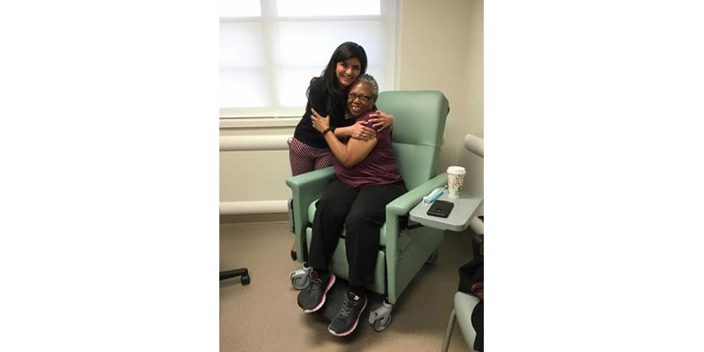 A female hospital patient embraces her physician.