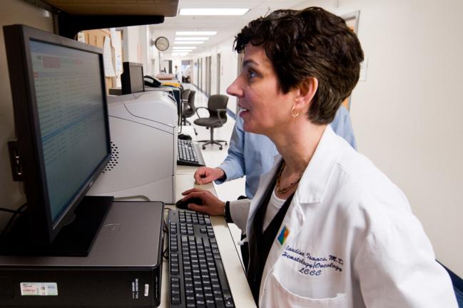 Dr. Isaacs looks intensely at a computer screen in a lab setting