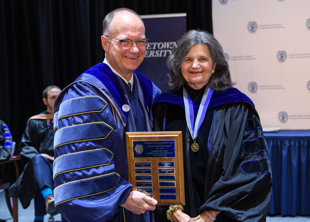 Jack DeGioia stands next to Phyllis Magrab, who holds her award