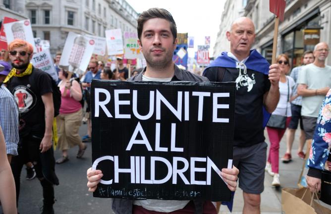 A man holds a sign at a demonstration that says 