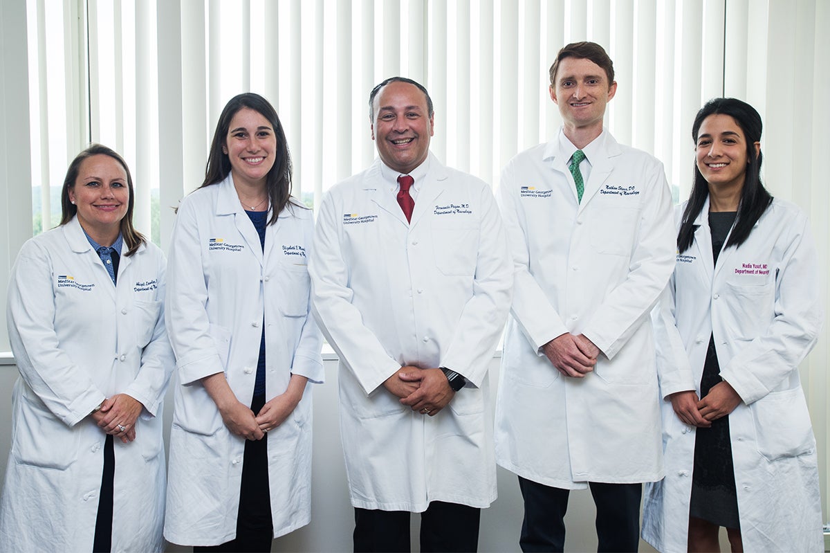 Fernando Pagan, MD, stands with several male and female participants in the Movement Disorders Fellowship Program