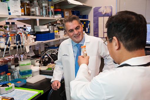 Giuseppe Giaccone looks at a test tube held by another researcher