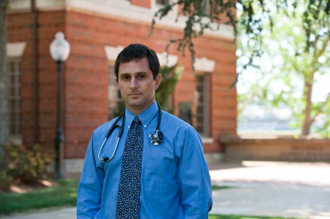 Dr. Merenstein stands outdoors near a red brick building