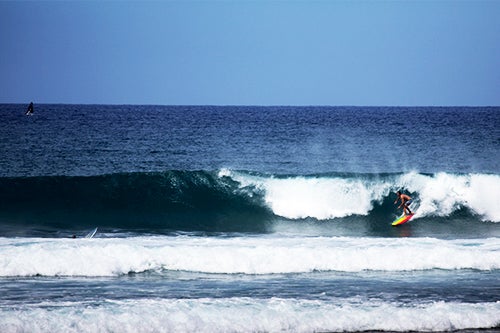 A surfer rides a wave