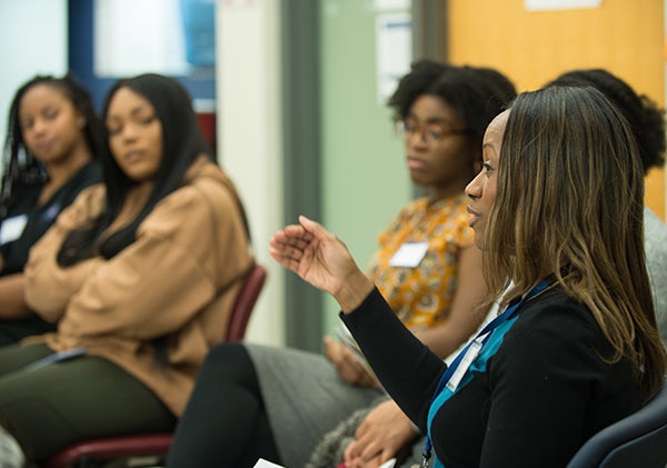 Several African American women listen carefully to Edwina Coleman, who is speaking.