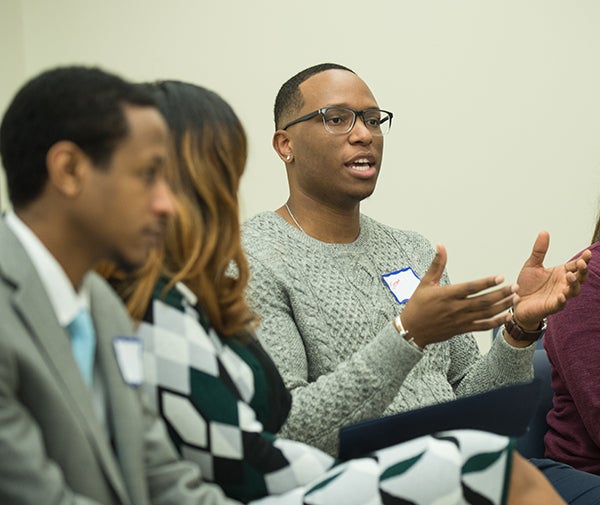 Jerome Murray speaks while two people listen.