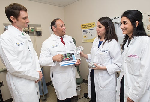 Dr. Pagan stands with three fellows in his program, two female and one male