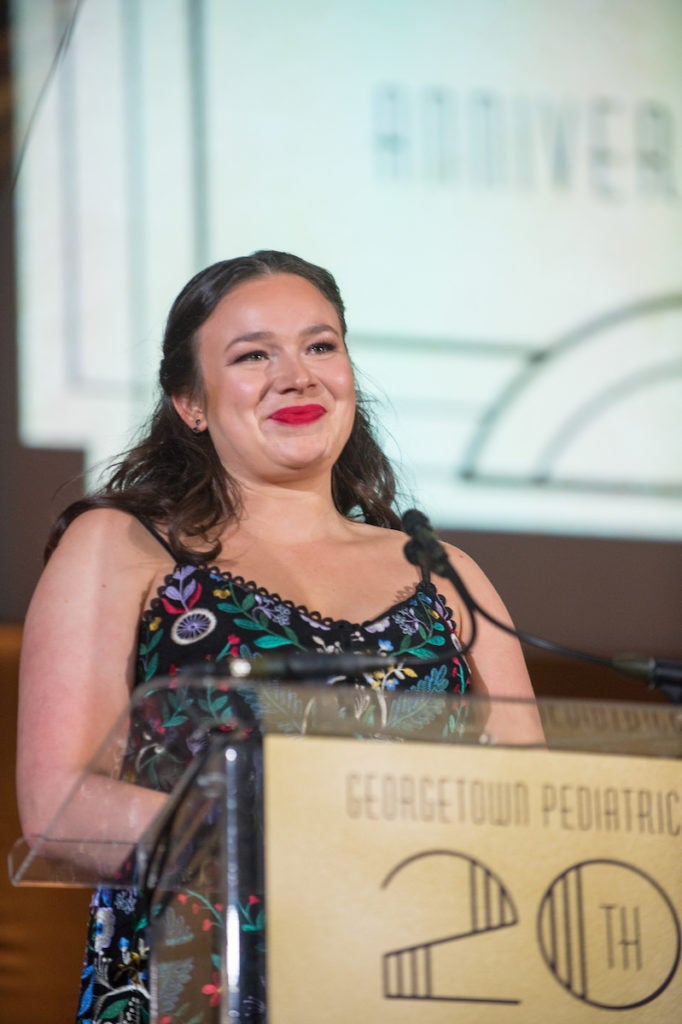 A woman stands at a podium.