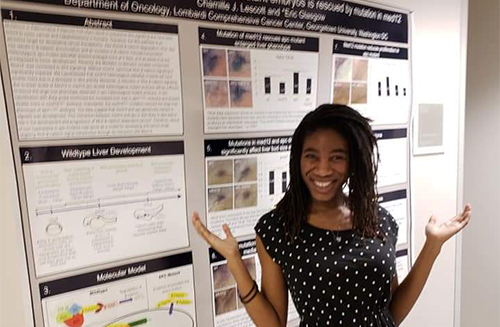 Chamille Lescott stands before her scientific poster presentation