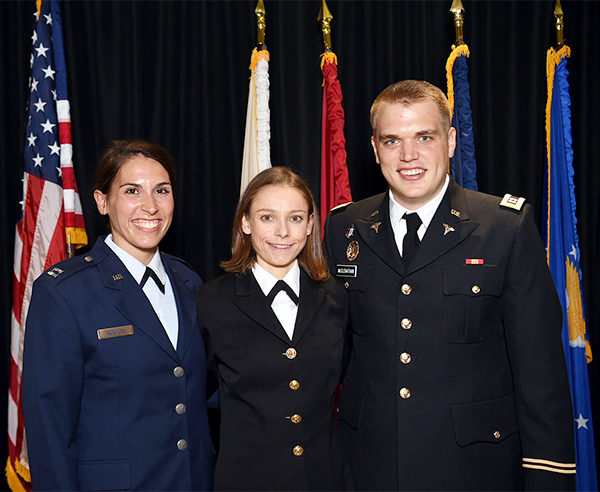 Three individuals stand side by side in military uniform