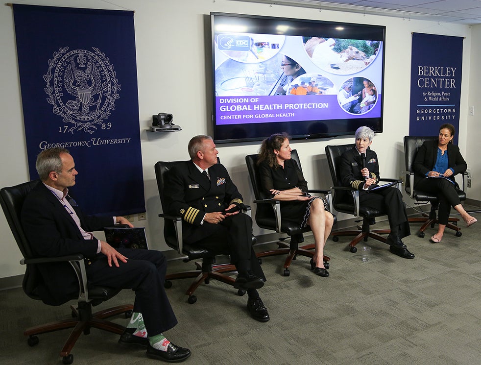 People seated in chairs in front of a video screen