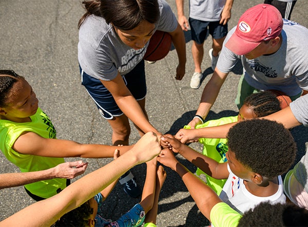 A group of children and young adults extend fists in a show of solidarity