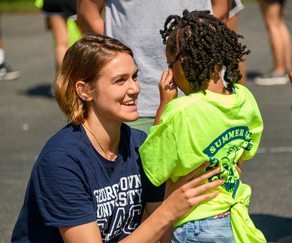 A counselor consoles a camper