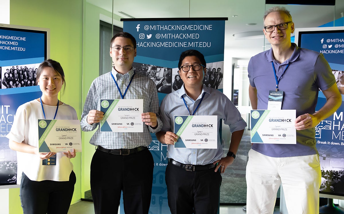 Four individuals stand together holding certificates