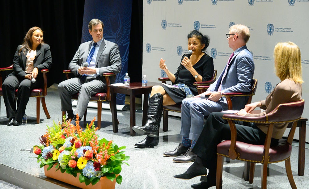 A group of people sits in chairs on a stage