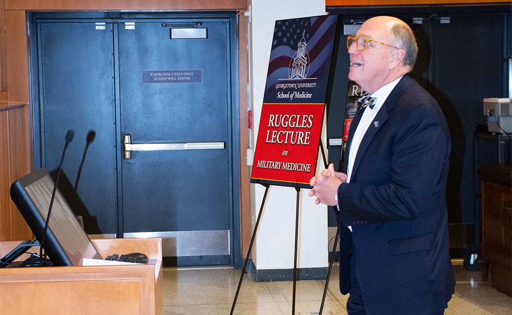 Dr. Mitchell speaks behind a podium