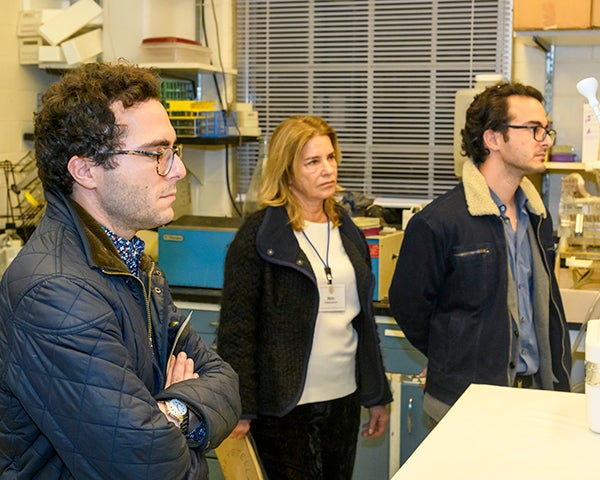 Three individuals stand in a lab