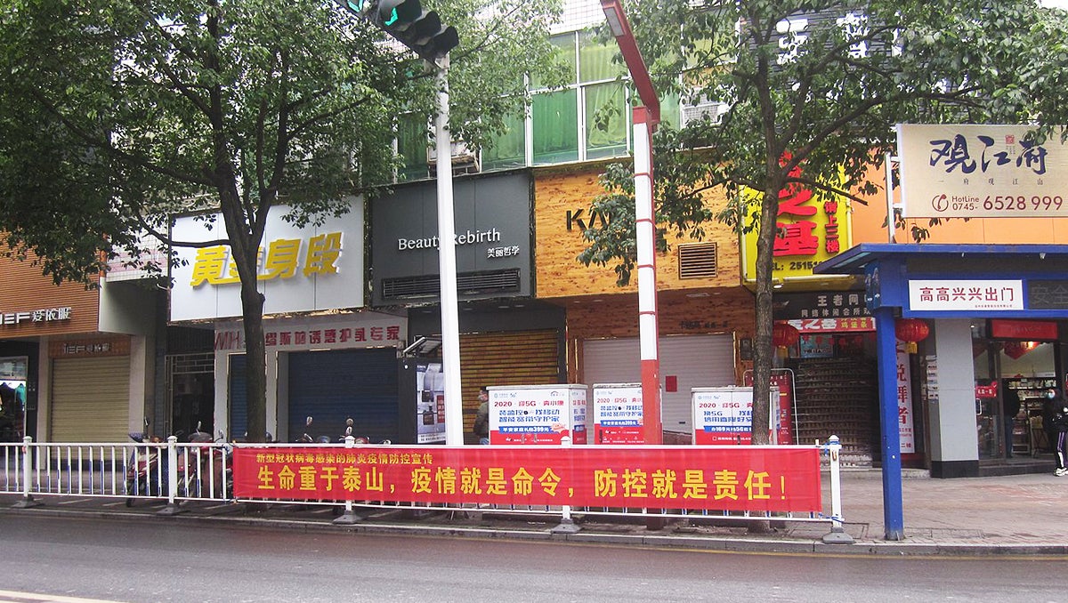 A street in Wuhan China empty but for a red banner along the roadside