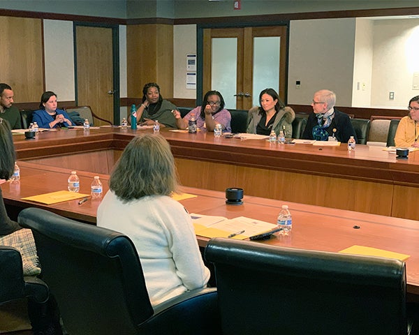 People sit around tables in a conference room