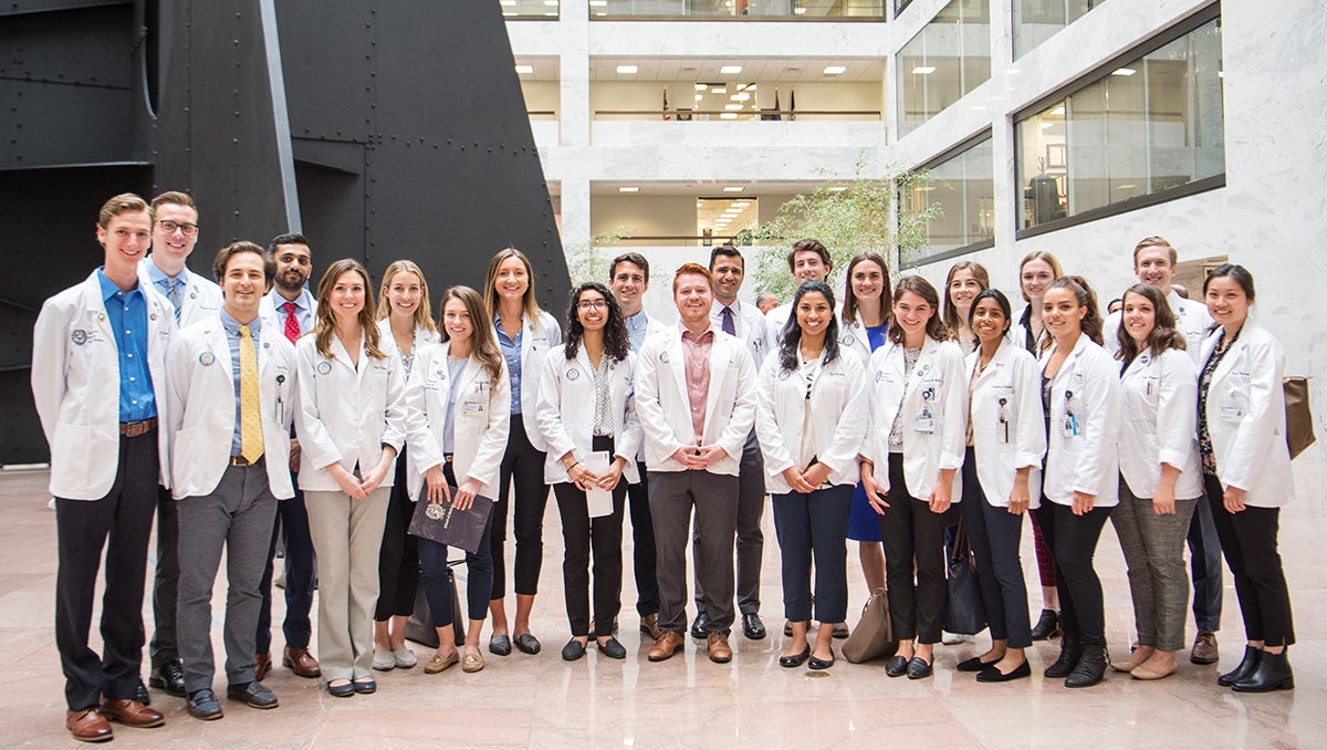 A group of medical students stand together for a group photo in a congressional building on Capitol Hill