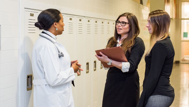 Ana Caskin speaks with two students