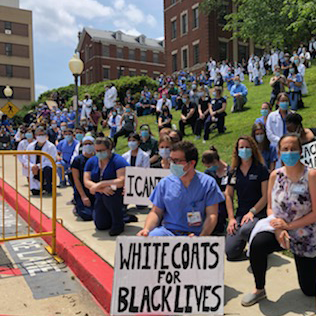 A large group of medical professionals participate in a protest outside MedStar Georgetown University Hospital