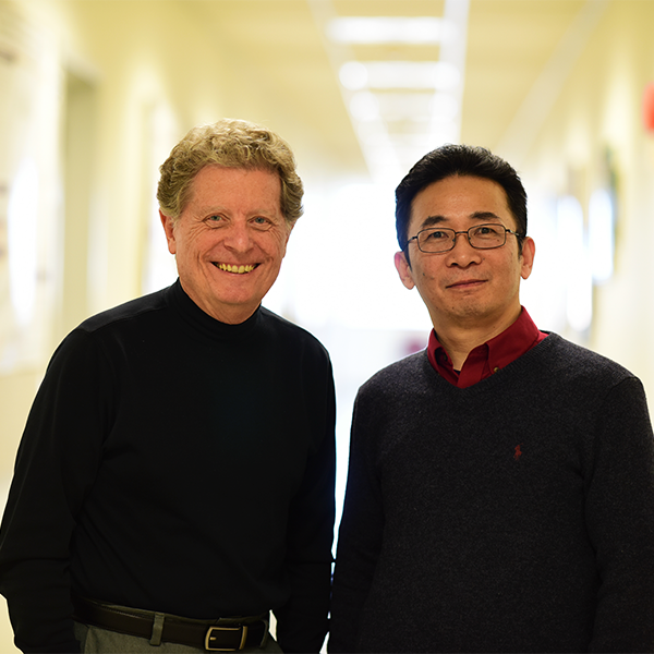 Richard Schlegel and Xiufeng Liu stand in a hallway