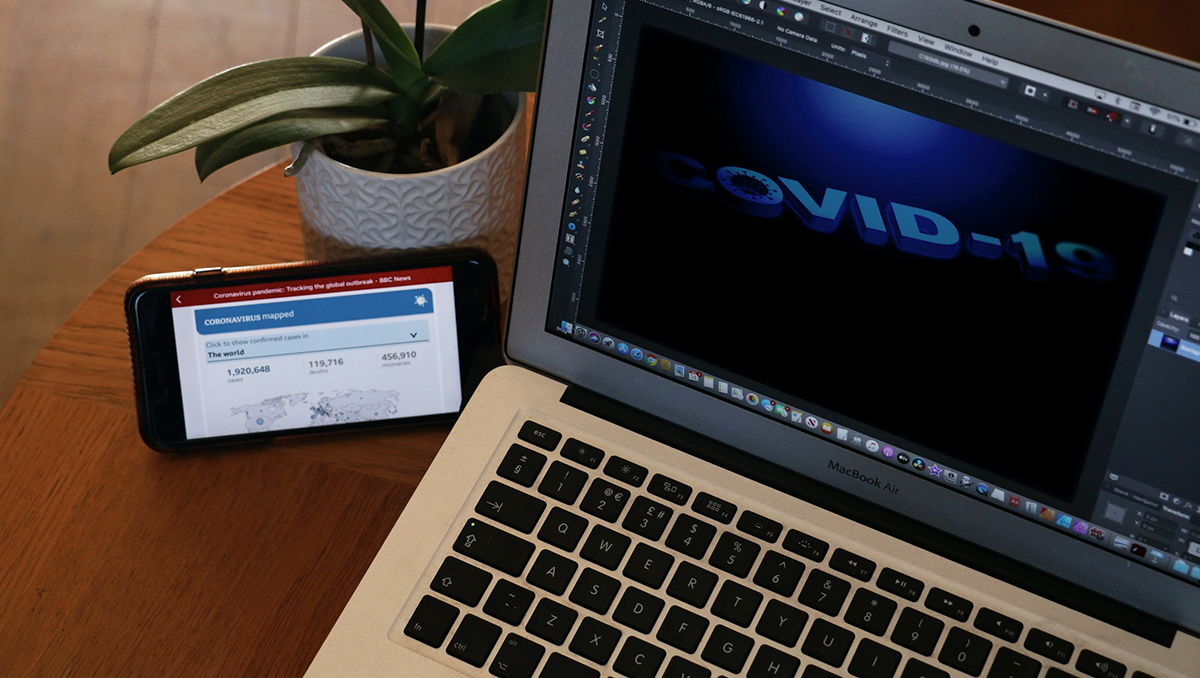 A computer and smartphone display COVID-19 information