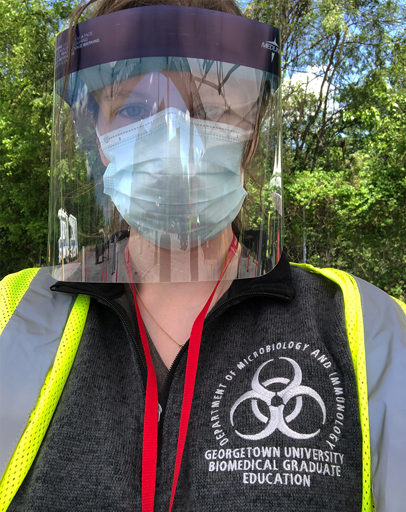 Suzie Stephenson in full personal protective equipment wearing a shirt with the Biomedical Graduate Education logo
