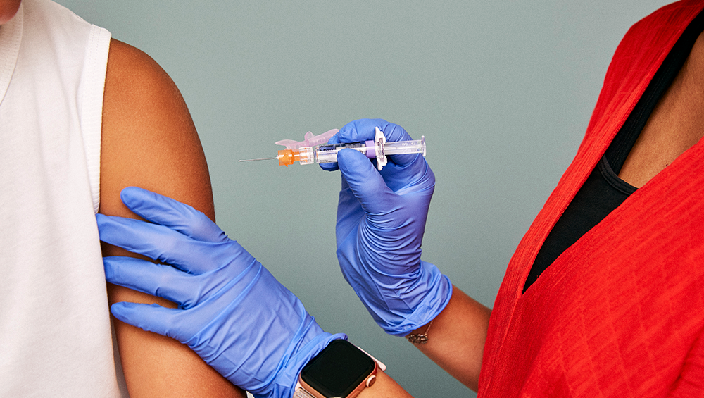 A medical professional administers a vaccine to the arm of an individual