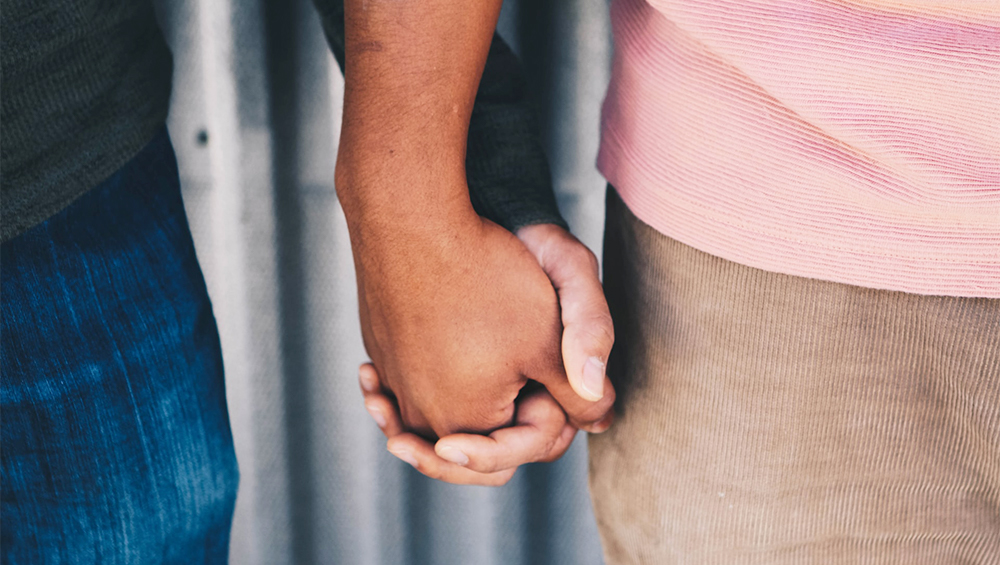 A closeup of two men holding hands