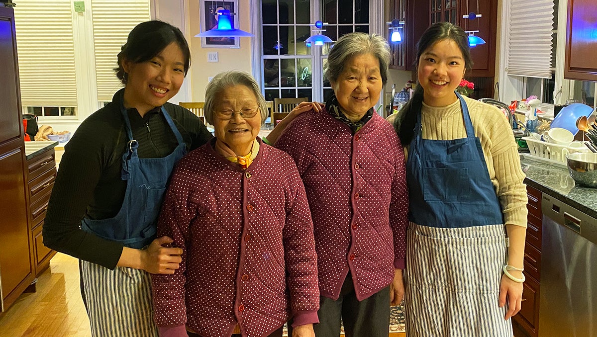 Four women stand in a home kitchen