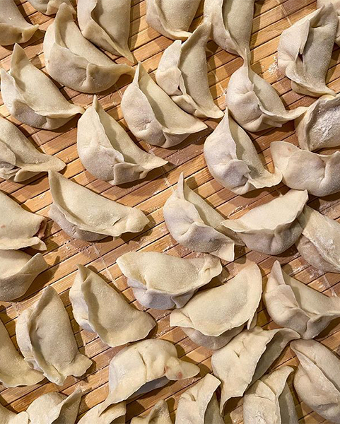 dumplings laid out on a floured wooden surface