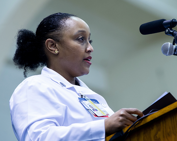 Dr. Michelle Roett speaks at a podium during White Coat