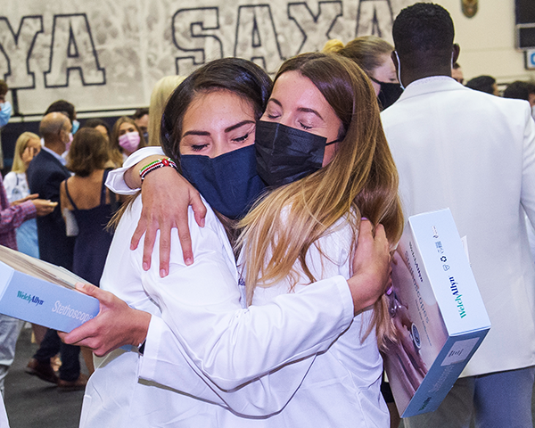 Two female medical students hug following the White Coat ceremony